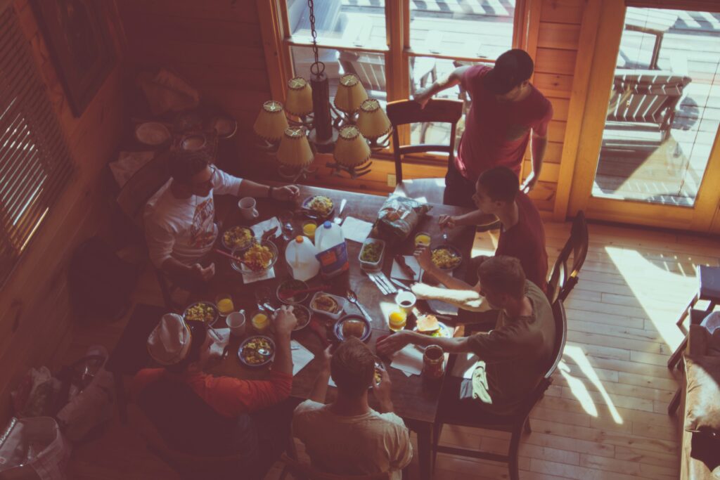 A group of people sits down for dinner together in an intimate home setting.