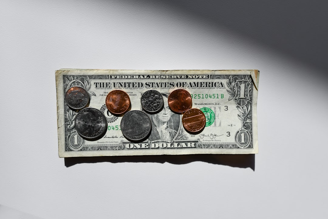 A dollar bill with coins on top. FAFSA and the return of SAT requirements is affecting many students' college applications.